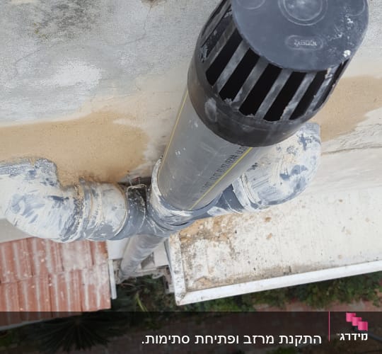 צינור פלסטיק שחור על גג עם לכלוך